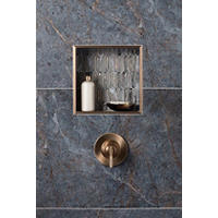 Thumbnail image of Detail view of shower walls and recessed shelf with porcelain marble patterned large format wall tile in blue/grey and neutral tans.  Glass mosaic used to accent niche and brushed bronze metal chanel as bullnose.